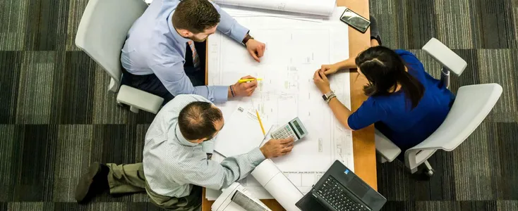 Top view of a team working on construction plans