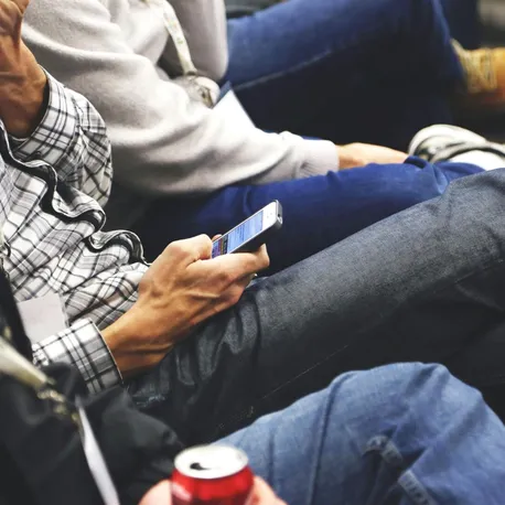 People sitting at a conference casually checking