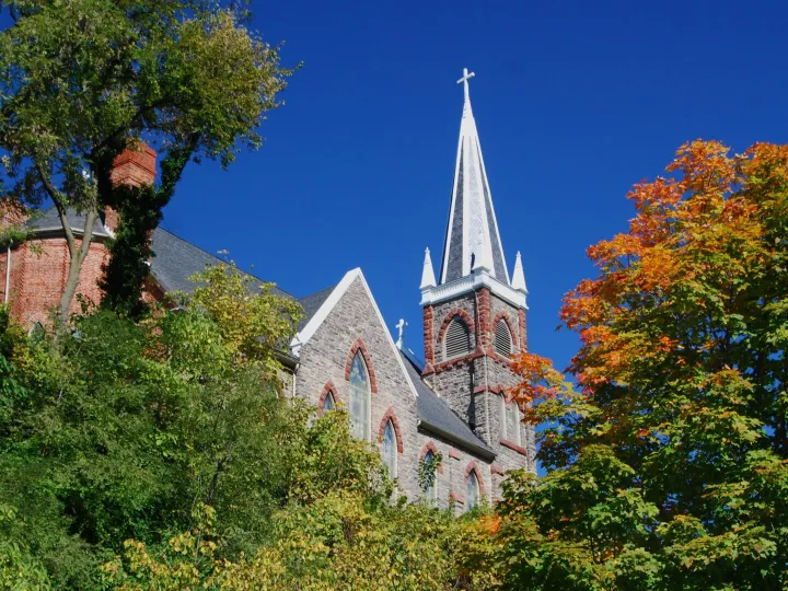 A classic church with a tall steeple surrounded
