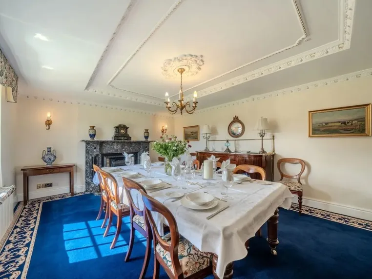 The dining room with a table laid for twelve guests