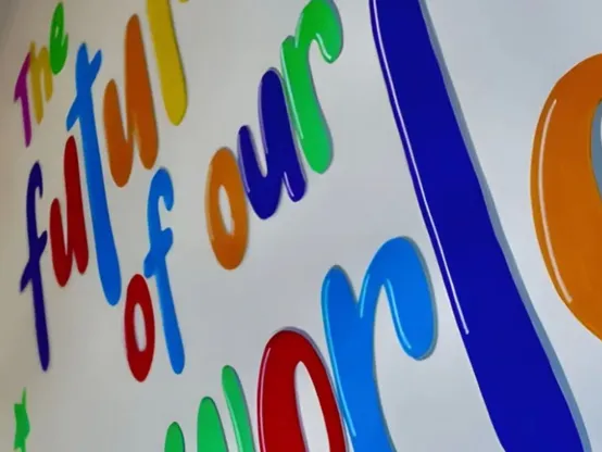 Hand painted wall mural in bright colours reading The future of our world