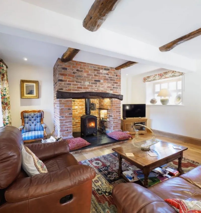 The lounge at Otters Retreat with an inglenook fireplace and log burning stove