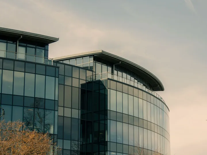Contemporary curved glass commercial office building in the UK at dusk