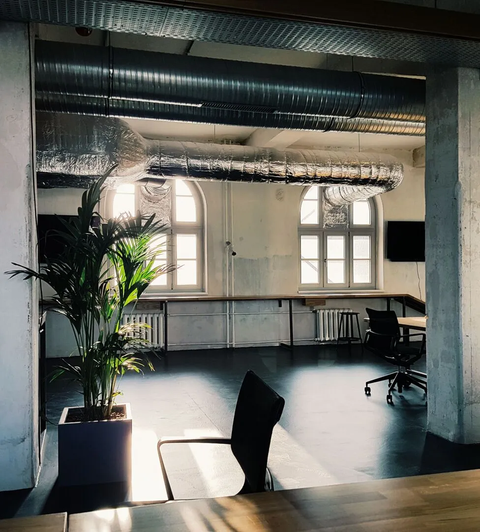 Modern workplace interior with exposed services and daylight