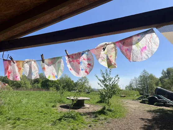 A line of hand painted paper bunting strung under the shelter roof