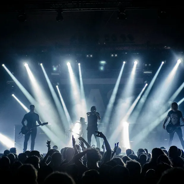Energetic live concert with musicians performing on stage, engaging the crowd with vibrant lighting effects.