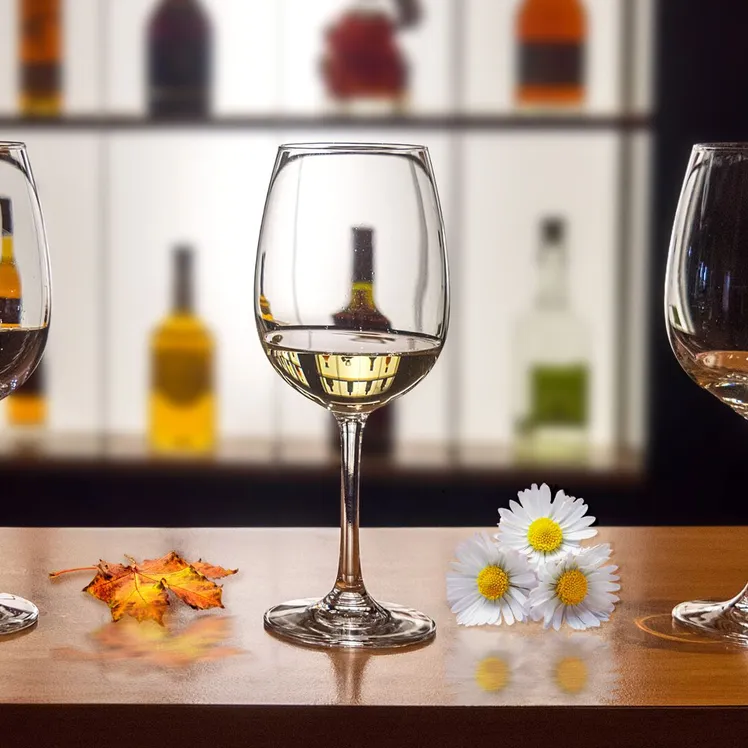 Wine glasses on a table with daisies