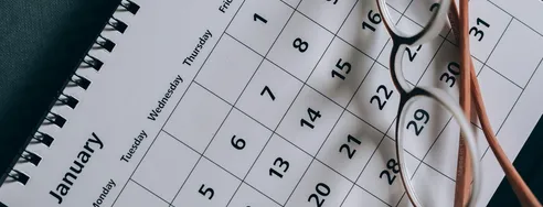 A close-up of a January calendar with eyeglasses