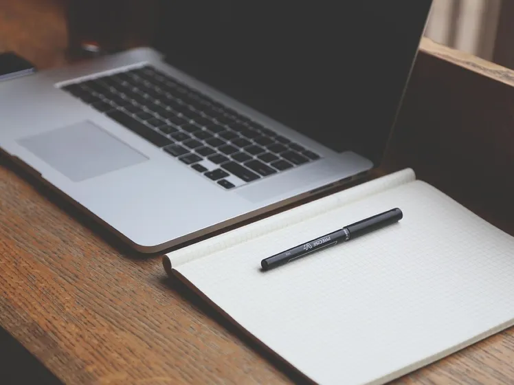Laptop and notebook on a desk