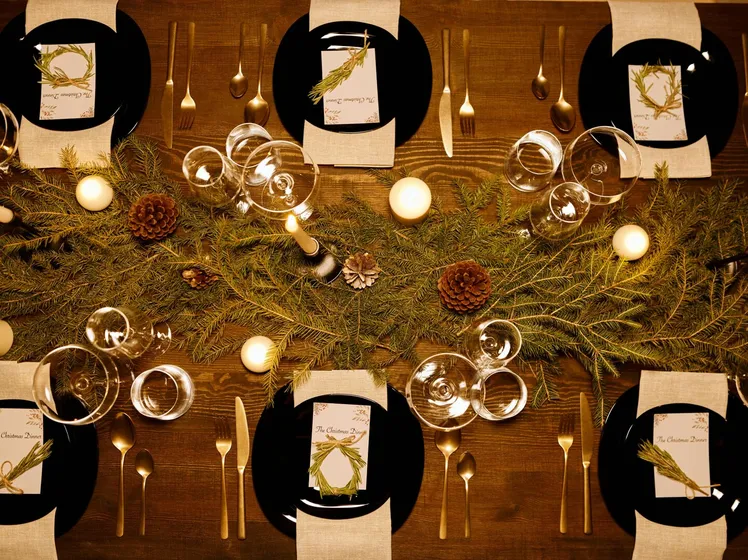 Elegant Christmas dinner table with candles, pine