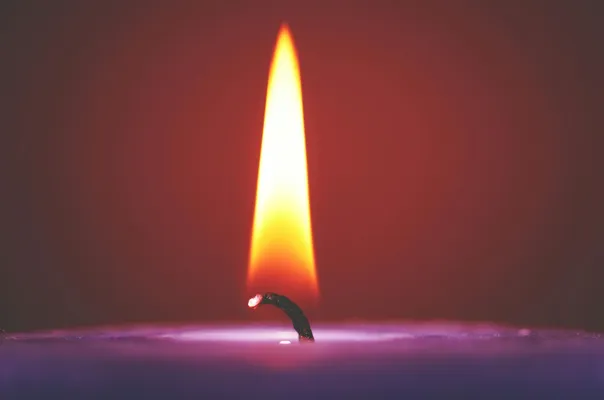 Close-up of a glowing candle flame against a dark
