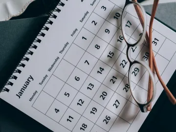 A close-up of a January calendar with eyeglasses
