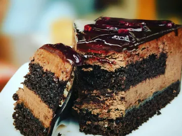 Close-up of a rich chocolate cake slice with blueb