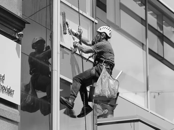 Professional window cleaner working on a