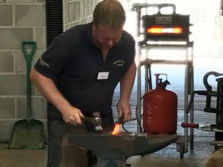 Farrier making a horse shoe