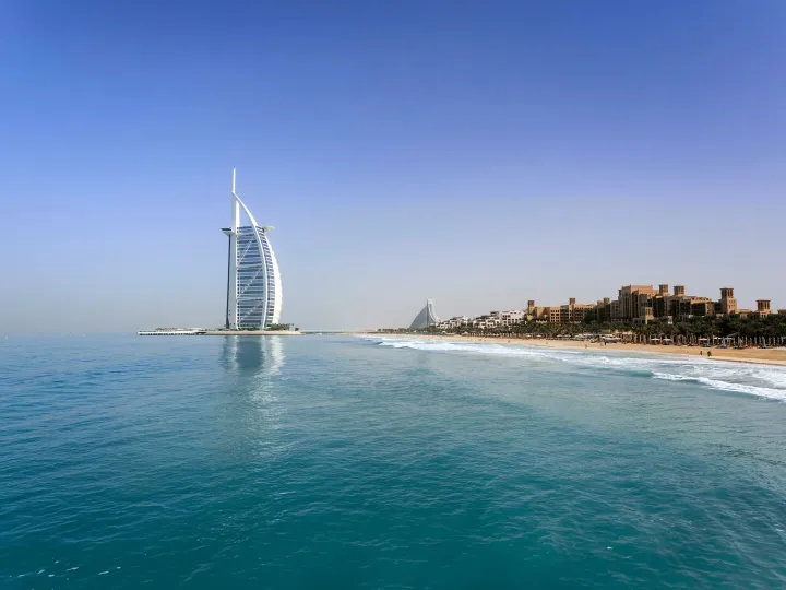 Iconic Burj Al Arab overlooking the pristine Dubai beach, perfect for travel and leisure.